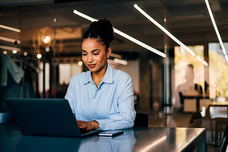 Een vrouw die achter haar laptop bezig is met website optimalisatie 
