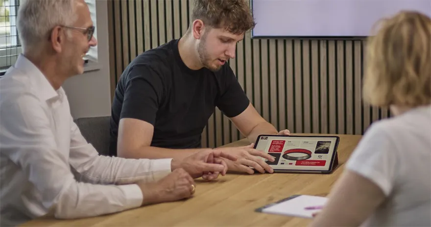 Man die naar een tablet kijkt met informatie erop getoont