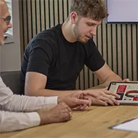 Man die naar een tablet kijkt met informatie erop getoont