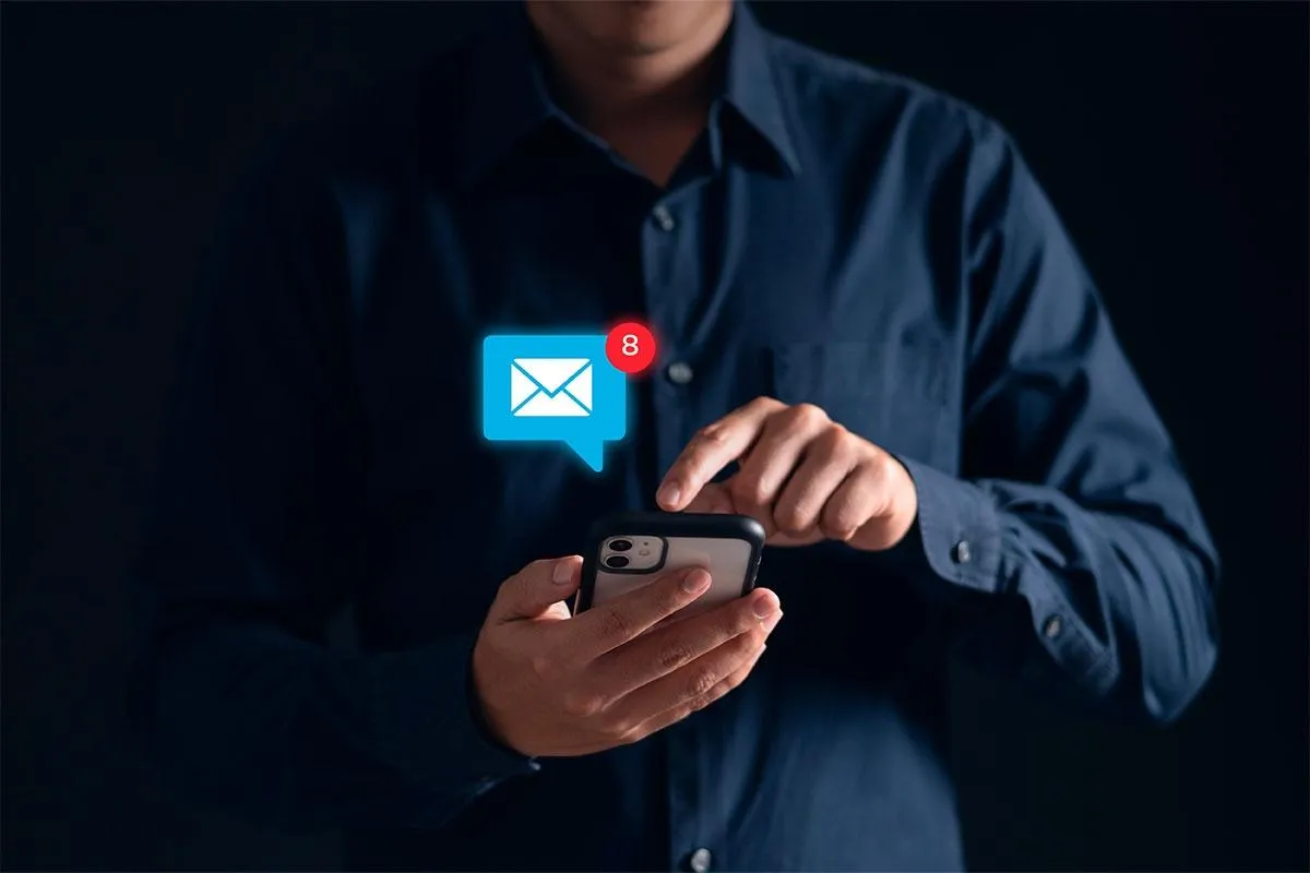 Man die op zijn telefoon klikt op het mail icoontje van een afstand 