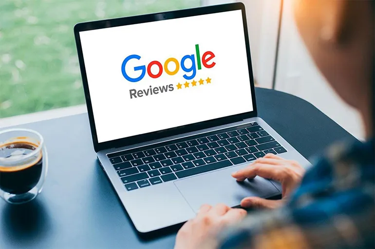 Iemand die op zijn laptop aan het kijken is naar Google reviews 