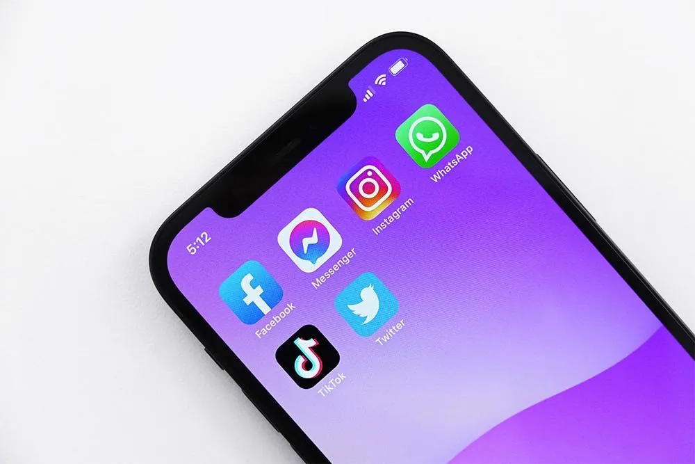 Een foto van een telefoon met 6 apps op het homescherm